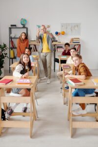 Nauczyciel przekazuje uczniom wiedzę stojąc za nimiby pokazać im inną perspektywę - ilustracja do mission statement Nauka Angielskiego Jelenia Góra Karo the Tutor